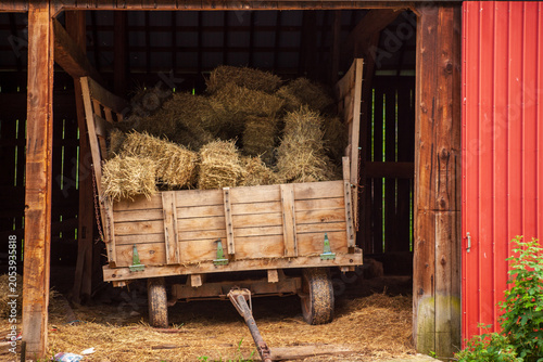 Barn with hay bales on a cart in rural setting near the farm