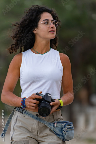 Young female photographer walking with camera in Phaselis ancient city in Turkey.