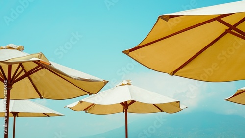 Yellow beach umbrellas under clear blue summer sky