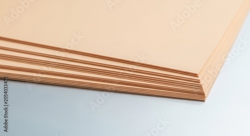 A stack of smooth pale peach cardstock paper sheets fanning out creating a gentle texture