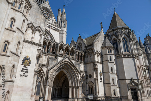 The majestic Royal Courts of Justice in London, UK, showcasing Gothic architecture under a clear blue sky.