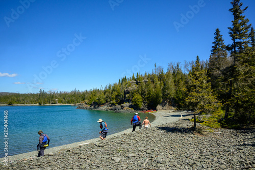 Fotografi sea kayak guides on ancient cobble berm Slate Islands