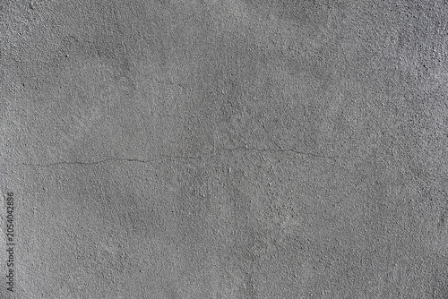 Textured gray plaster wall with a horizontal crack.
