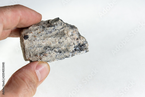 Tableau sur toile Holding a granite gneiss stone isolated on white background