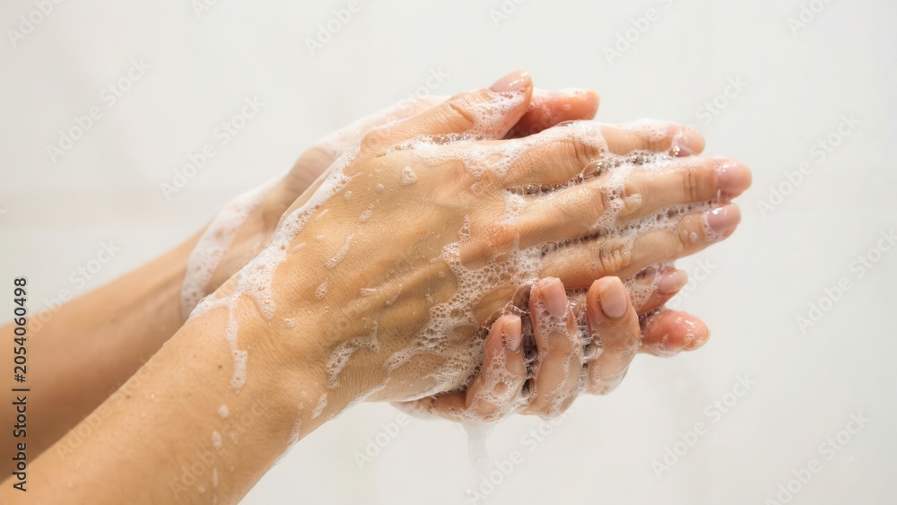 Fototapeta premium Woman washing hands with soap bubbles isolated on white background