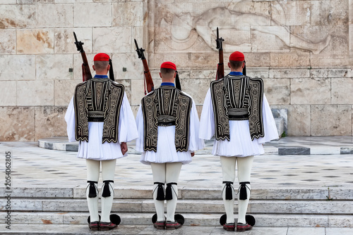 Traditional Evzones guards standing in ceremonial uniform in Athens, Greece. Iconic symbol of Greek history, heritage and national identity near the Hellenic Parliament.