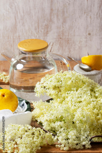 Elderflower Cordial Ingredients with Fresh Blossoms Lemon Sugar and Water on Rustic Table
