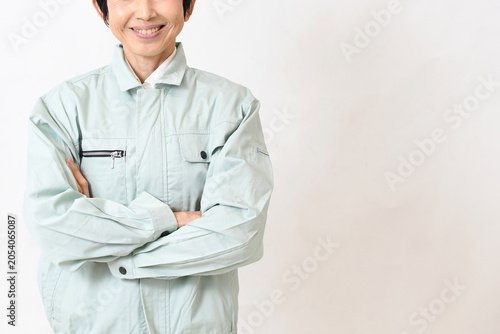 笑顔で腕組みする笑顔のアジア人女性作業員