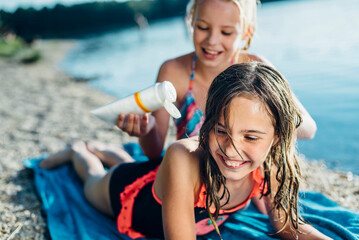 Portrait of laughing girl on the beach with her friend