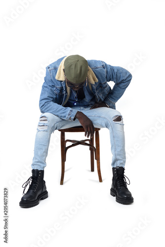 Front view of a young African man sitting in a chair look down