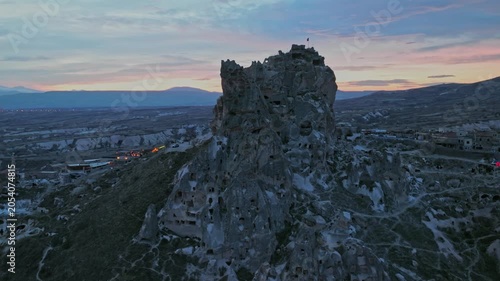 Drone view of Ortahisar Castle towering above the historic town of Ortahisar in Cappadocia, Turkey. A remarkable example of rock-carved architecture.