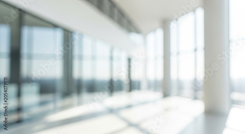 Blurred Modern Office Interior with Large Windows and Bright Sunlight.