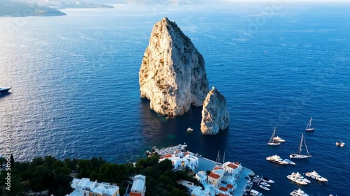 Aerial view of large rock cliffs in the blue sea with sailing boats near the coast of capri italy