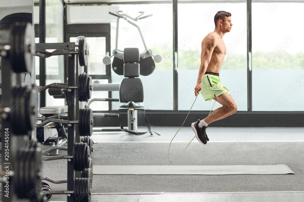 Fototapeta premium Young fit man jumping a rope