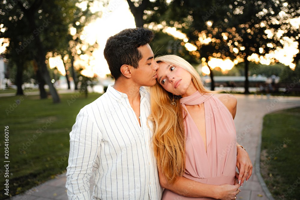 Fototapeta premium Couple embraces with affection at sunset in a peaceful park setting