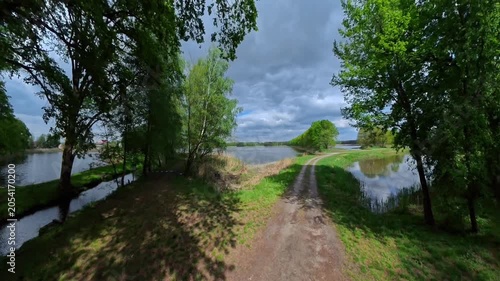A lake and a country path under an overcast sky