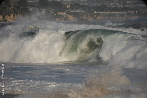 Giant shorebreak crashing on the sand at the wedge