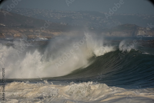 Giant shorebreak crashing on the sand at the wedge