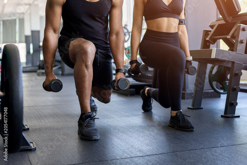 Cuadro en lienzo Close up of young fitness performing weighted lunges in gym
