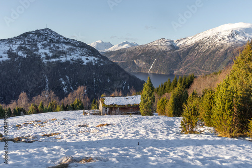 A beautiful winter landscape in Toresetra with old, traditional wooden building. A wintertime scenery near Eidsdal in Geiranger Unesco World Heritage site, More og Romsdale region, Norway.