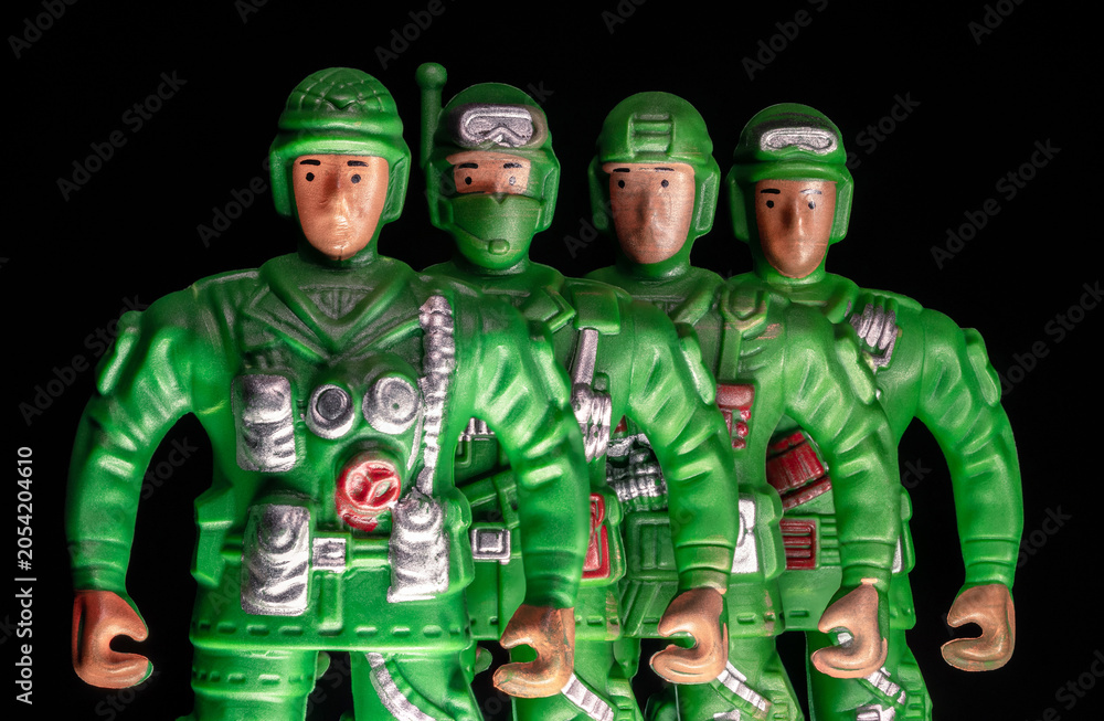 Obraz premium A special forces unit stands against a black background. Four special forces soldiers in uniform