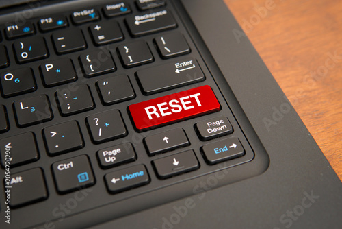 Close up of a computer keyboard with a red reset key, representing restarting, recovery, renewal, fresh start, system reset, troubleshooting, and business transformation concepts.