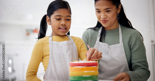 Child, mother and candles on birthday cake for baking at home, celebration or special day. Parent, decoration or girl with rainbow dessert at party for help, preparation or learning in family kitchen