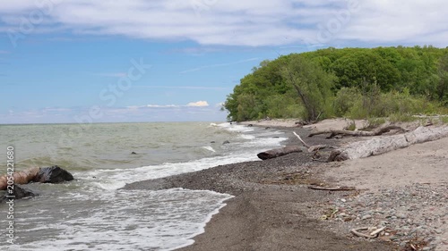 Waves rolling onto the rocky shore and driftwood along the lakeshore