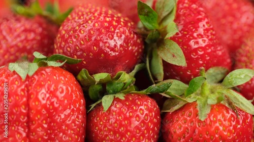 Juice fresh strawberries with green tails close up, rotation