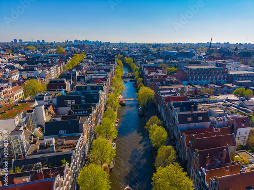 Oudezijds Voorburgwal canal with Dutch style waterfront building in Central Amsterdam, Netherlands. Canal Ring Area of Amsterdam is designed as a UNESCO World Heritage Site. 