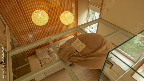 Fotografie Cozy reading nook with beanbag and bed on a mezzanine level with glass floor