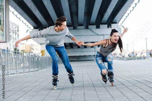 Young couple rollerblading having fun urban area lifestyle