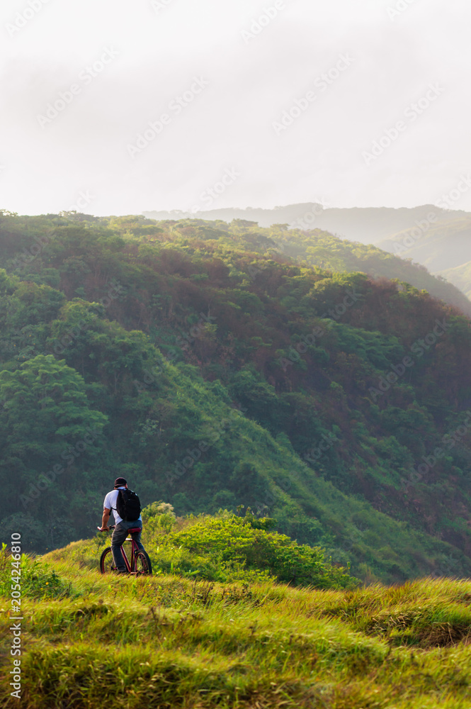 Obraz premium Cyclist looking at a scenic mountain landscape in Nicaragua