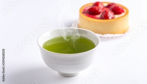 White ceramic cup of steaming green tea, vivid bright liquid against plain background, fresh and calming atmosphere with vibrant color contrast…