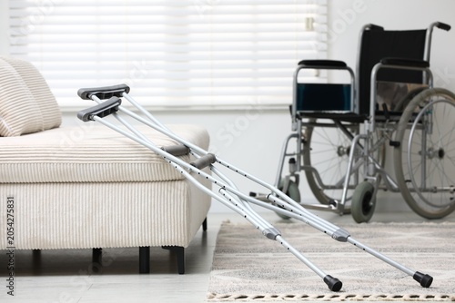 Cuadro en lienzo Modern wheelchair and axillary crutches near sofa indoors