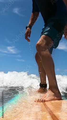 Vertical slow motion POV from surfboard camera during a surf takeoff with dynamic wave motion and cinematic ocean action