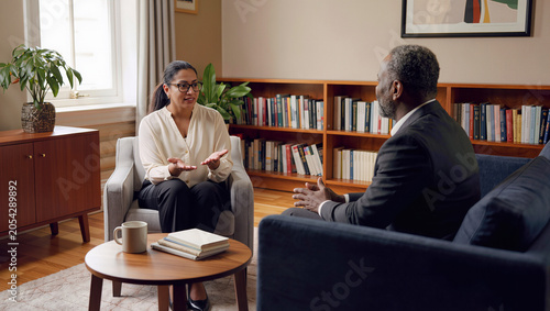 Young woman consulting mature man in therapy session