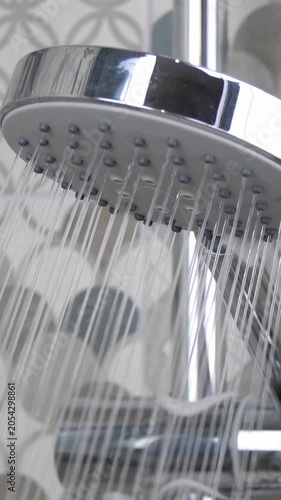 Vertical shower head with flowing water. Modern bathroom features sleek design and relaxing atmosphere. Enjoy refreshing experience in stylish surroundings.