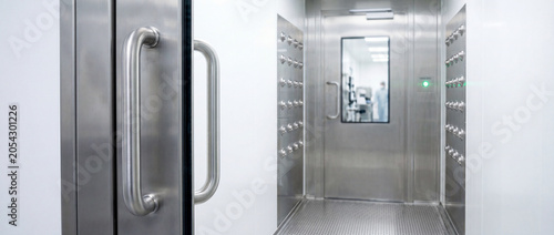 Сleanroom air shower and stainless steel door in sterile laboratory pass-through for pharmaceutical facility