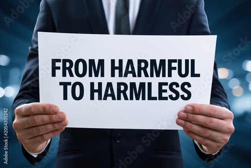 Corporate man holding a sign from harmful to harmless