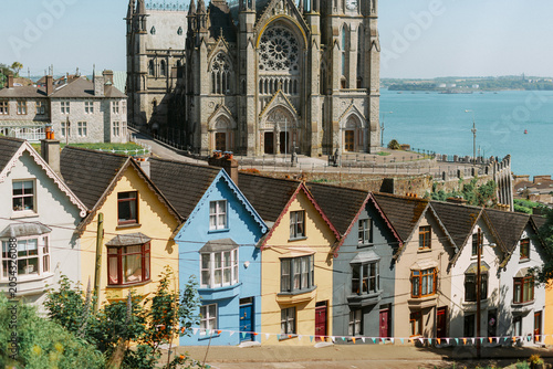 Colorful houses beneath St Colman's Cathedral in Cobh County Cork Ireland