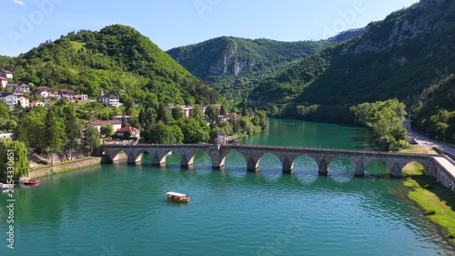 Visegrad, Bosnia and Herzegovina – May 30, 2026: Wide panoramic drone view of Mehmed Pasha Sokolovic Bridge surrounded by green mountains and the Drina River