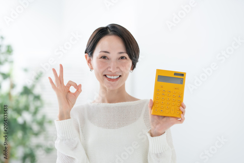 Photos 電卓を持つ女性 OK,オーケー,OKサイン,オーケーサイン,丸,了解,簡単,成功,安心,承諾,満足