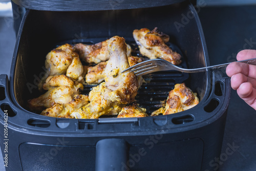 Roasted chicken wing in modern home air fryer.