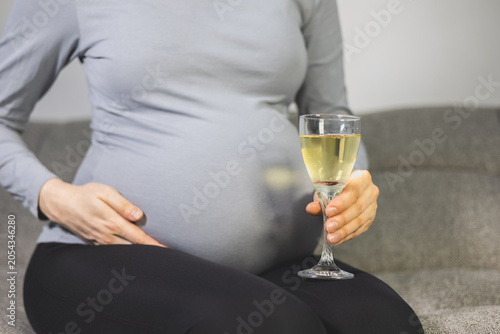 Drinking alcohol during pregnancy. Dangerous habit. Close up.