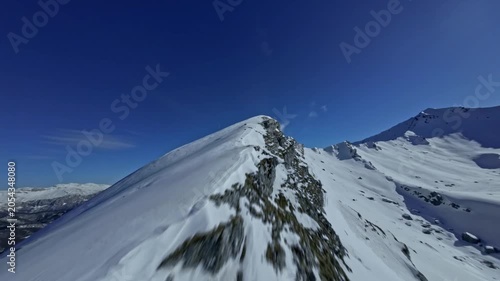 FPV Drone Shot Diving Fast Down Snowy Mountain Ridge lope