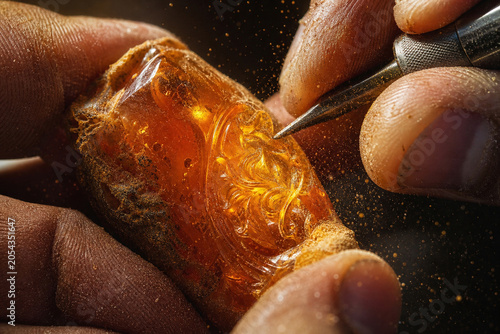Skillful Hands Carving Intricate Details into Amber