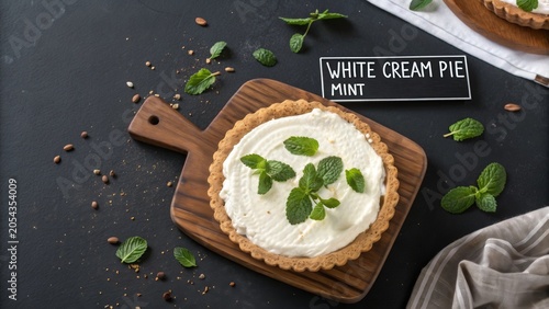 Delicious homemade white cream pie topped with fresh mint on a wooden board at a cozy kitchen setting