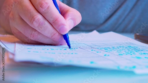 Cinematic macro of a hand filling a survey or job application form. Defocused background, soft window light. Visualizes questionnaire, voting, human resources hiring process and research.