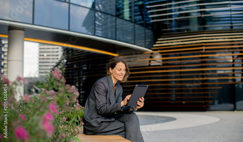 Woman using tablet while si...